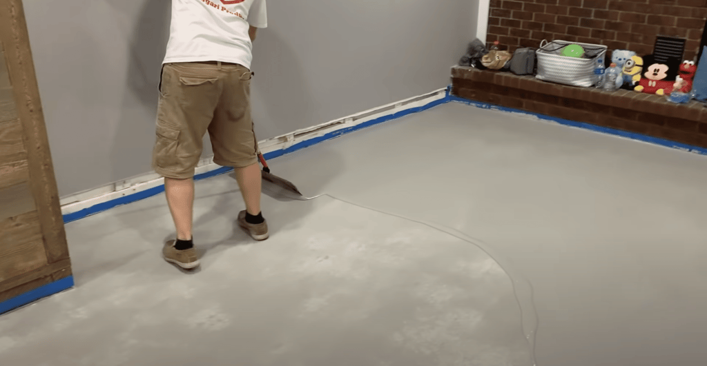 We apply the scratch coat by simply pouring it onto the floor, and once again, use a large squeegee to spread it throughout the floor.