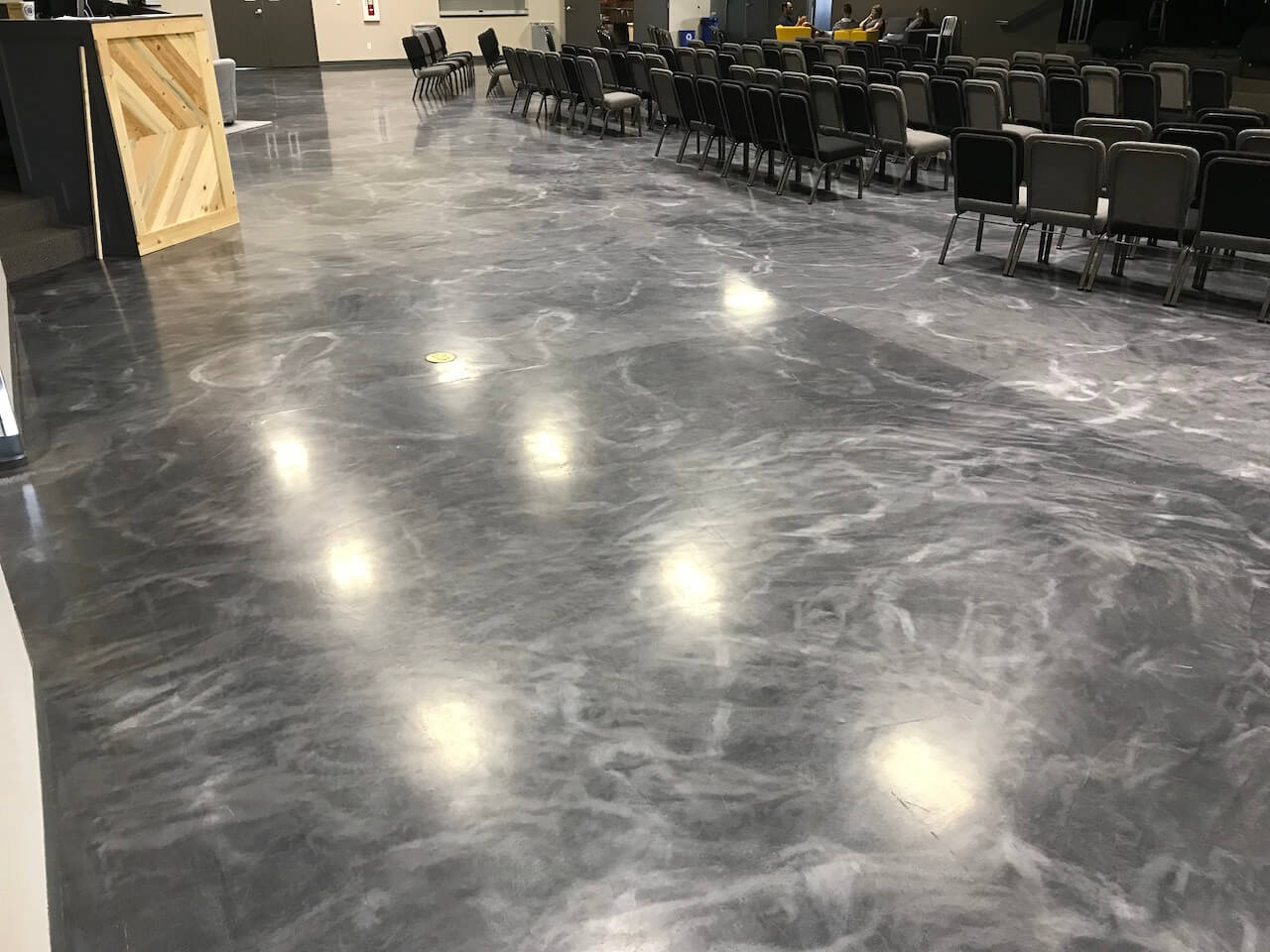 A gray and white epoxy floor with a matte top coat installed in a church all-purpose room.