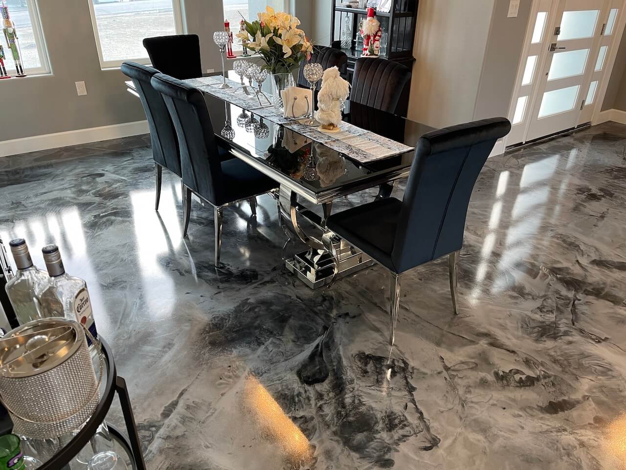 A modern dining room in a brand new home with black, gray and white epoxy floors installed.
