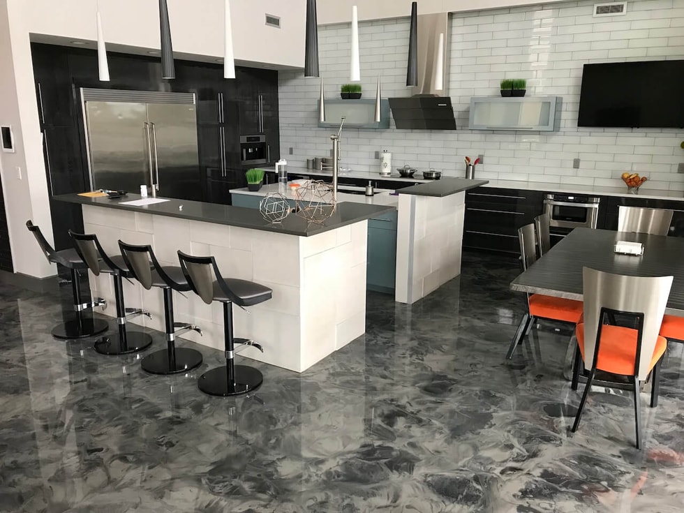 Durable epoxy floors installed in a modern, industrial, open-concept kitchen and dining area.  These floors feature gray and black epoxy and a gloss urethane top coat.