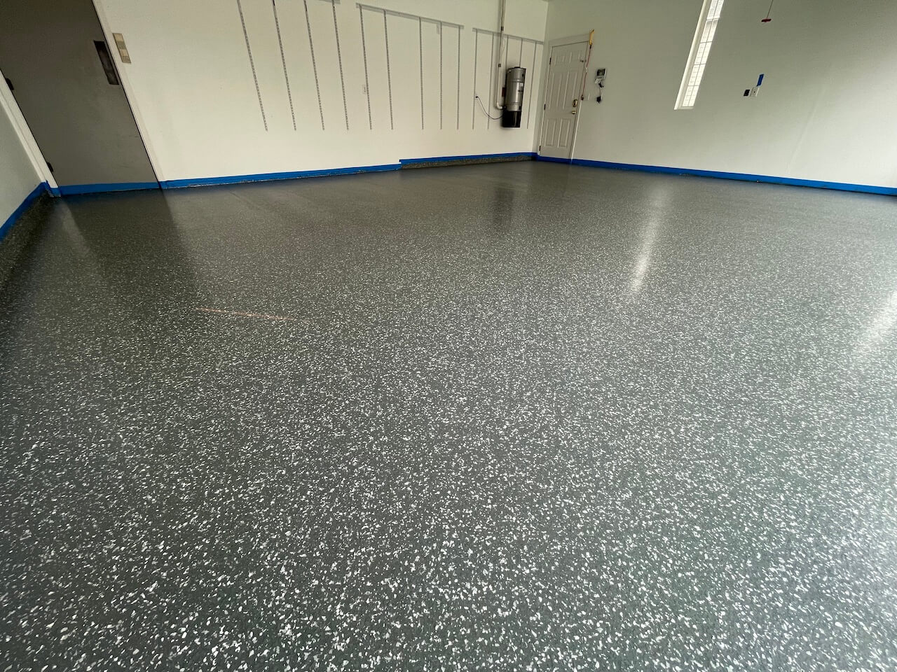 This garage features a flake or chip floor in black and white.  The flake floor is covered with an epoxy topcoat.