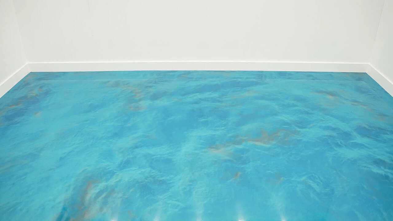 A metallic epoxy garage floor in a turquoise blue ocean color.  The walls and trim are both bright white.