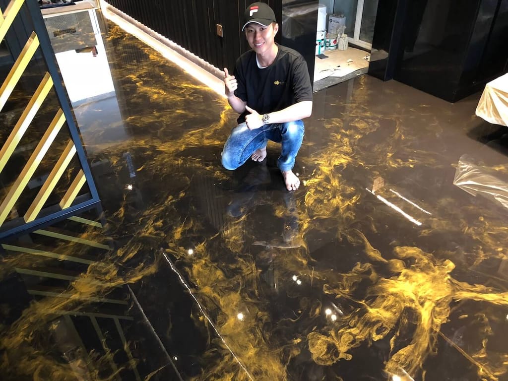 A gorgeous DIY epoxy floor installed by a homeowner.  The floor features a dark brown coffee base with vibrant gold swirl highlights.
