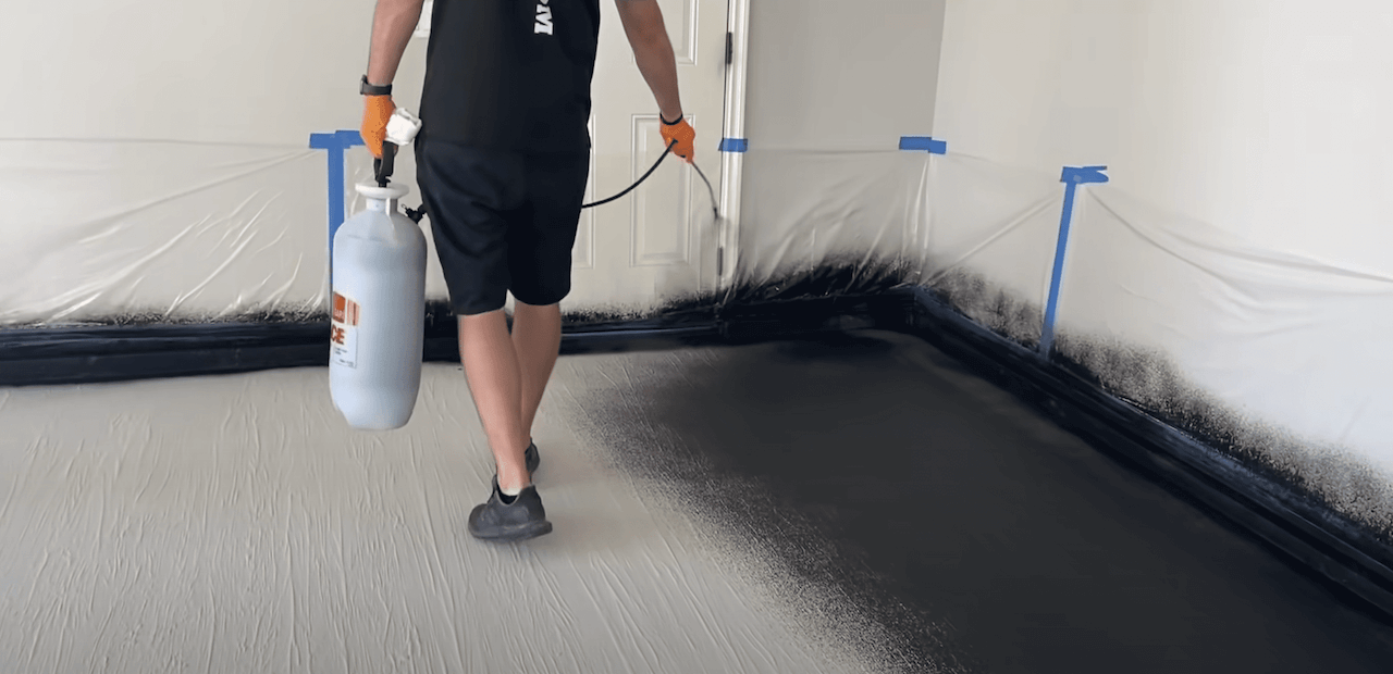 Using a fine mist sprayer to apply the Leggari stain to the dried and textured concrete overlay.