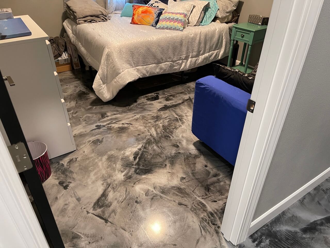 A beautiful epoxy floor installed in a bedroom and hallway.