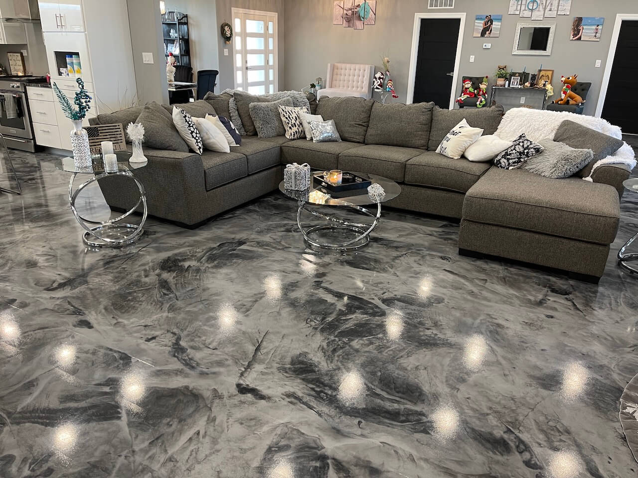 Gorgeous gray and black metallic epoxy floor in a home with a couch and tables.